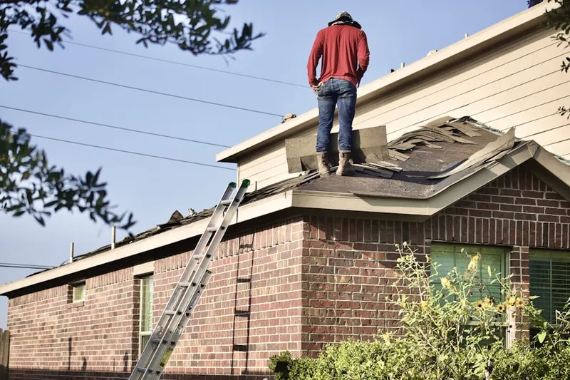 Professional roofer working on a residential roof in Winslows